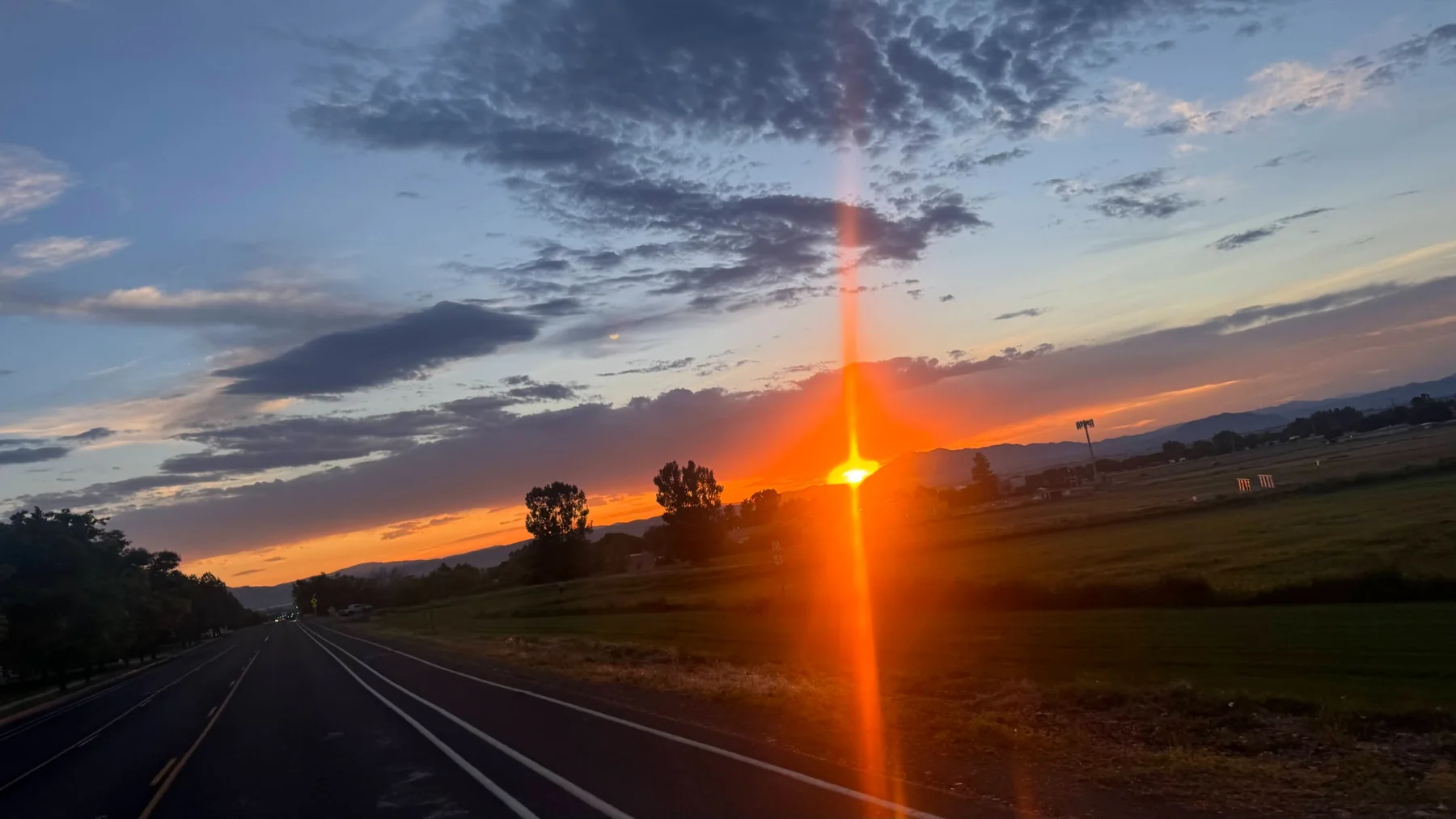 A bright Cache Valley sunset beside an open road